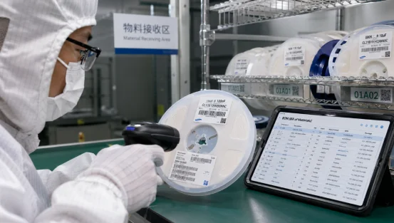 Worker scanning a component reel barcode against a digital BOM list in a PCBA receiving area